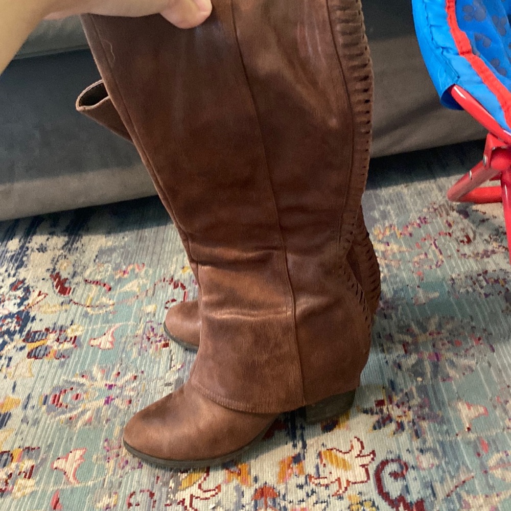 Brown tall boots with corset detail on back.